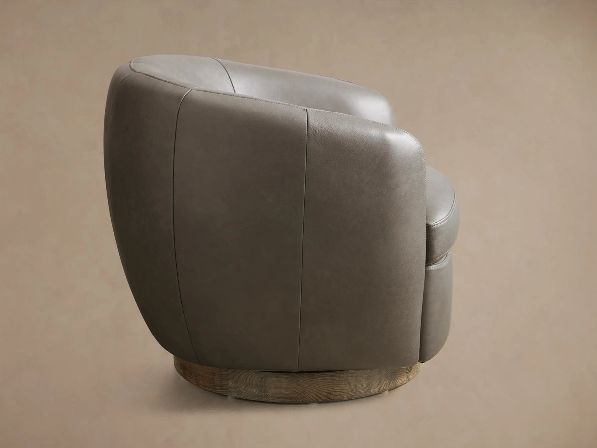 Front view of the grey Cerrito Leather Swivel Chair, featuring a round, gold-toned textured swivel base.