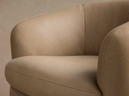 Close-up of the beige Cerrito Leather Swivel Chair, showing the curved back, armrest, and detailed stitching.
