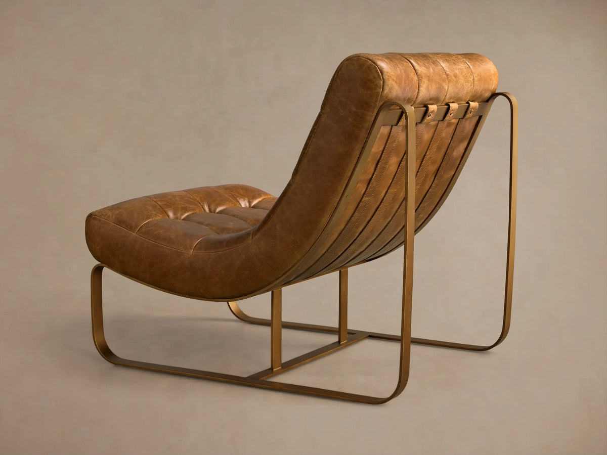 Close-up of the tan Callaway Leather Chair's padded back, bronze metal frame, and leather straps with rivets.