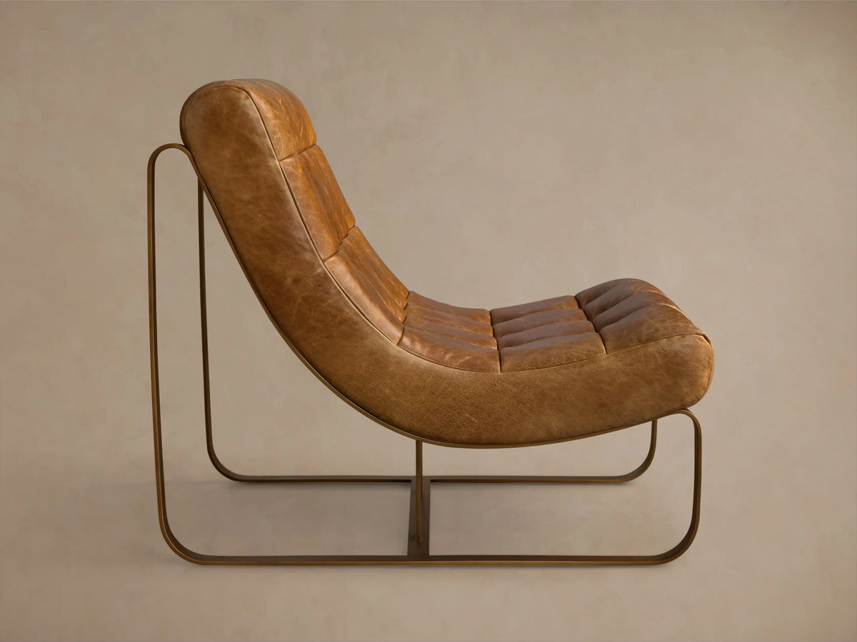 Rear-side view of a brown Callaway Leather Chair with tufted seat, leather strap back, and a bronze metal frame.