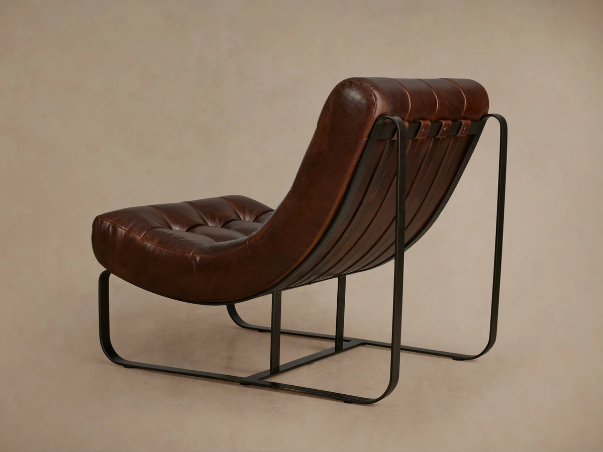 Back view of the Callaway Chair showing rich brown leather upholstery with vertical stitching and black metal frame accents.