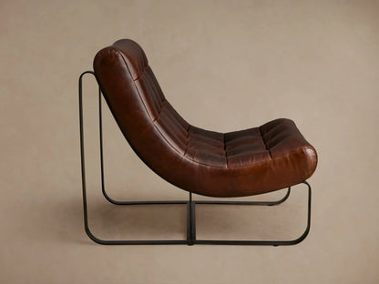 Brown leather Callaway chair with tufted seat and backrest. Curved design on black metal frame, viewed from an angle against a neutral background.