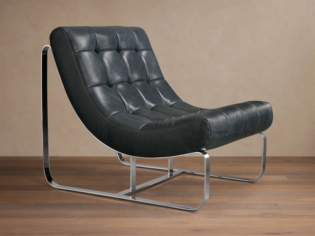 Front view of the dark blue-grey tufted leather Callaway Leather Chair with a curved chrome sled base.