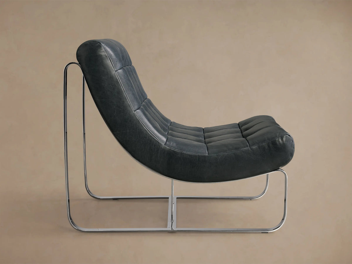 Side profile of the dark grey Callaway Leather Chair with tufted cushions, a sleek chrome frame, and visible back support straps.