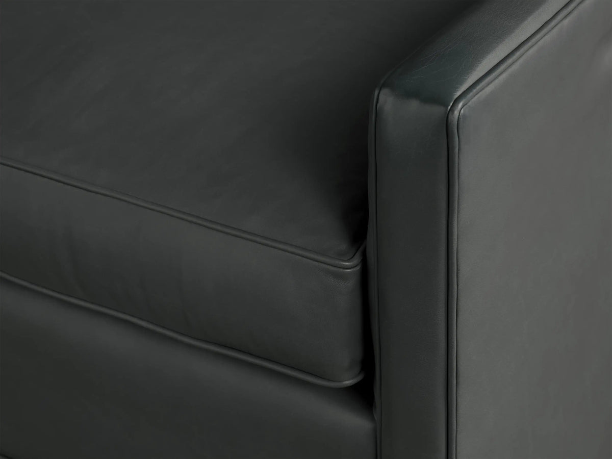 Front view of a dark grey leather Rudy Swivel Chair. Features a boxy design with a visible black swivel base.