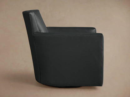 Dark charcoal Rudy Leather Swivel Chair, angled back view, high back, subtly curved arm, on a light brown studio background.