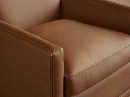 Front view of the Rudy Leather Swivel Chair. Smooth tan leather, clean modern design with piped edges, on wood flooring.