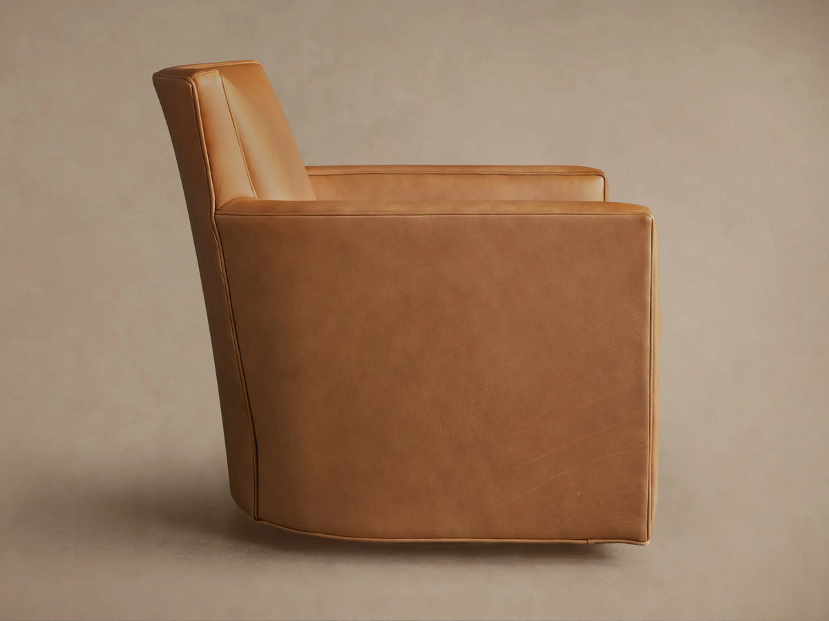 Back of a Rudy Leather Swivel Chair in caramel brown, featuring clean lines, wide back, subtle arms, and dark swivel base.