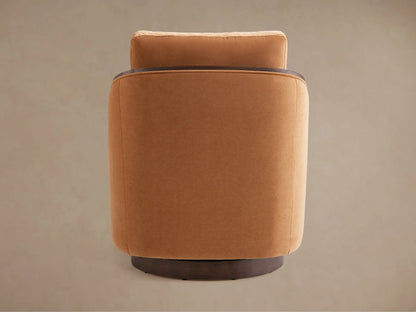 Close-up of Pomona Swivel Chair, featuring soft camel fabric upholstery and dark exposed oak arms.
