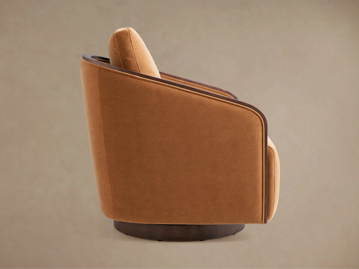Back of Pomona Swivel Chair, upholstered in rich orange fabric, with a dark curved oak trim and round swivel base.