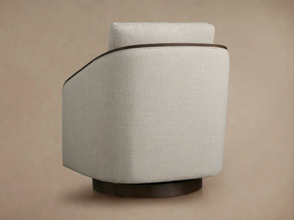 Pomona Swivel Chair with soft, light fabric cushions, dark exposed oak arm edges, and curved design. Close-up view.