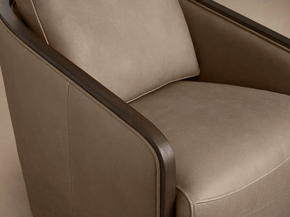 Pomona Leather Swivel Chair in beige leather with exposed oak edges, featuring rounded back, armrests, and a swivel base on a wooden floor.