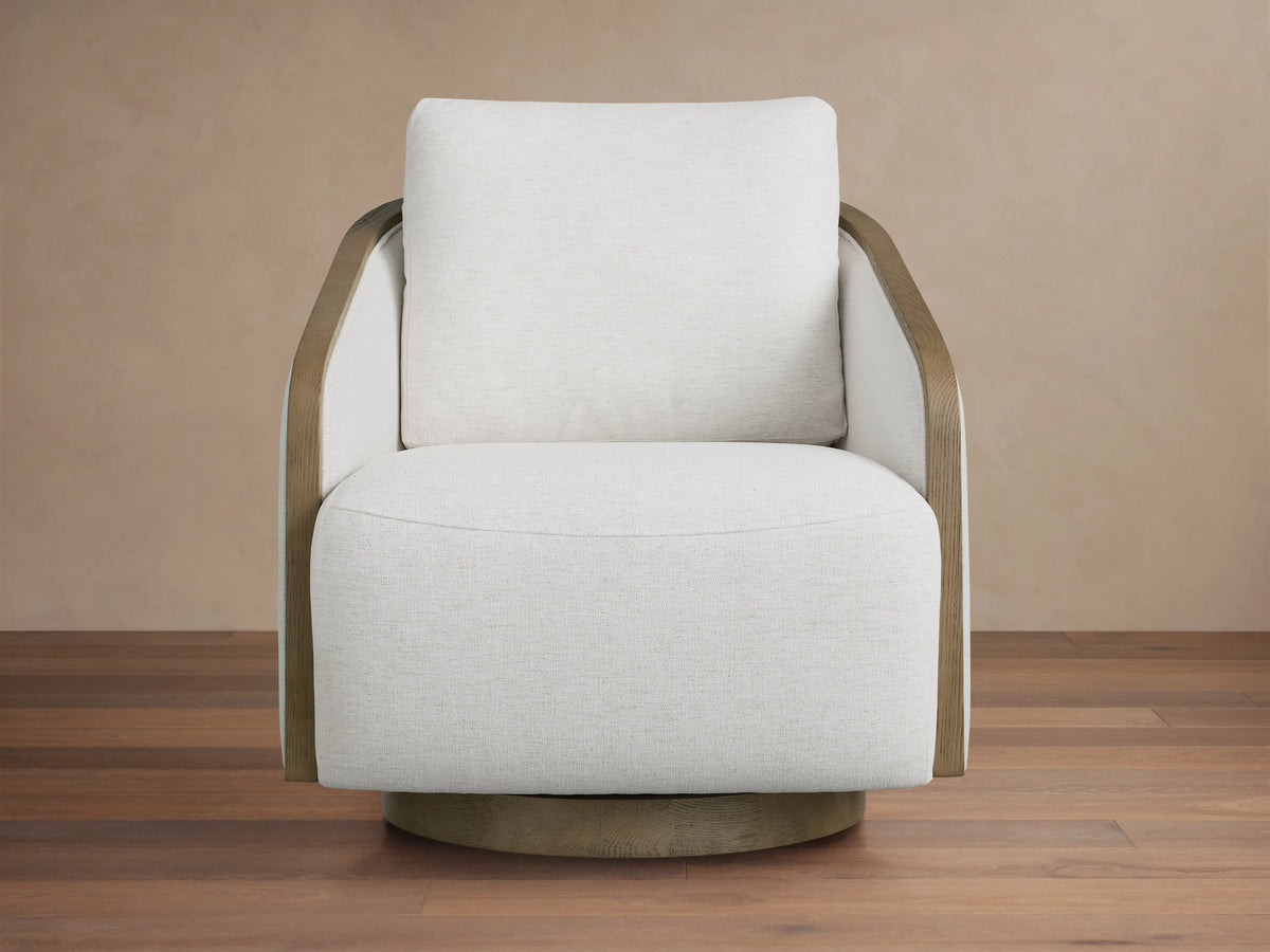 Front view of the beige Pomona Swivel Chair with exposed oak arms and swivel base, on a light rug.