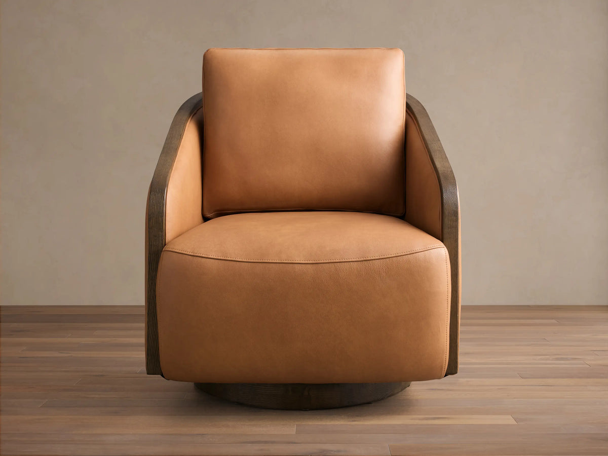 Front view of the tan leather Pomona Leather Swivel Chair with dark oak arms and a dark round swivel base.