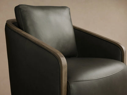 Front view of the dark olive Pomona Leather Swivel Chair with exposed oak edges on the arms and round swivel base.