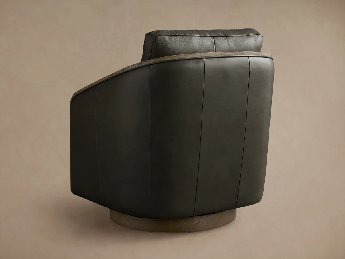 Front view of the dark gray leather Pomona Leather Swivel Chair, featuring curved oak armrests and seat stitching.