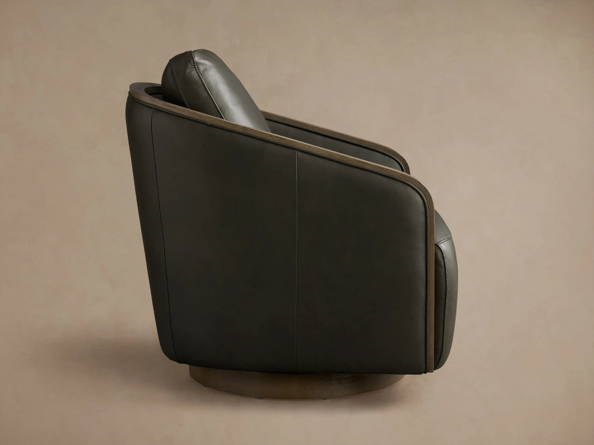 Rear view of a dark green leather Pomona Leather Swivel Chair with exposed oak trim and a rounded swivel base.