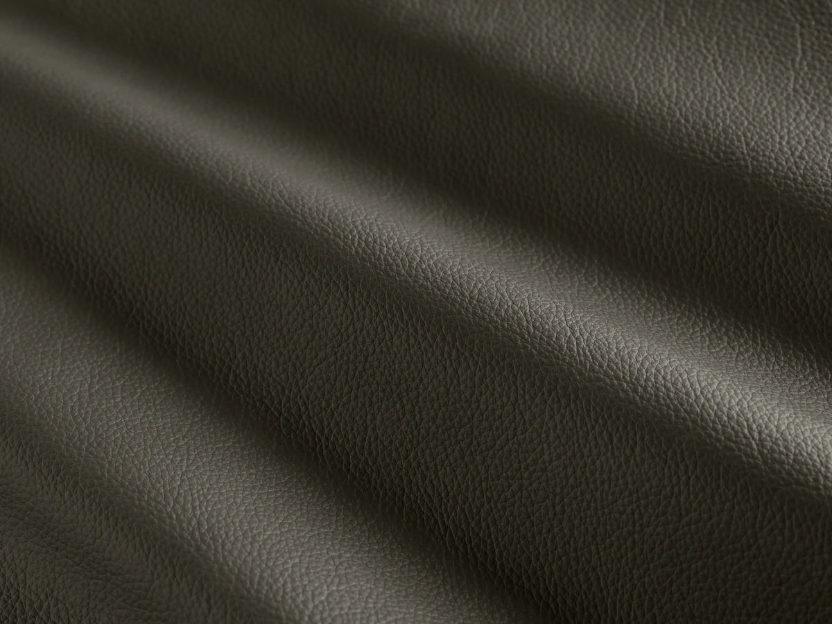 Side profile of the deep charcoal Pomona Leather Swivel Chair, with exposed oak edges and a visible swivel base.
