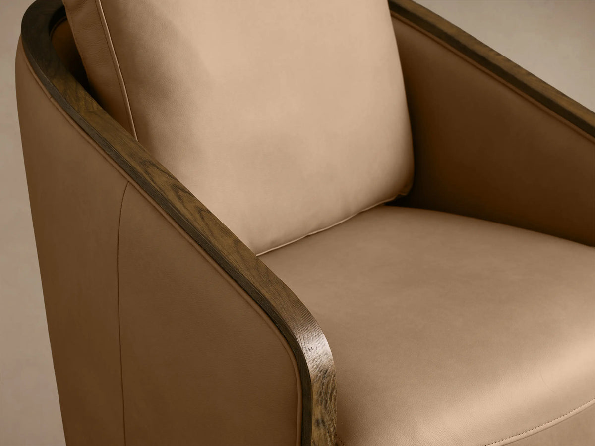 Front view of a light tan leather Pomona Leather Swivel Chair with curved oak arms and a round oak swivel base.