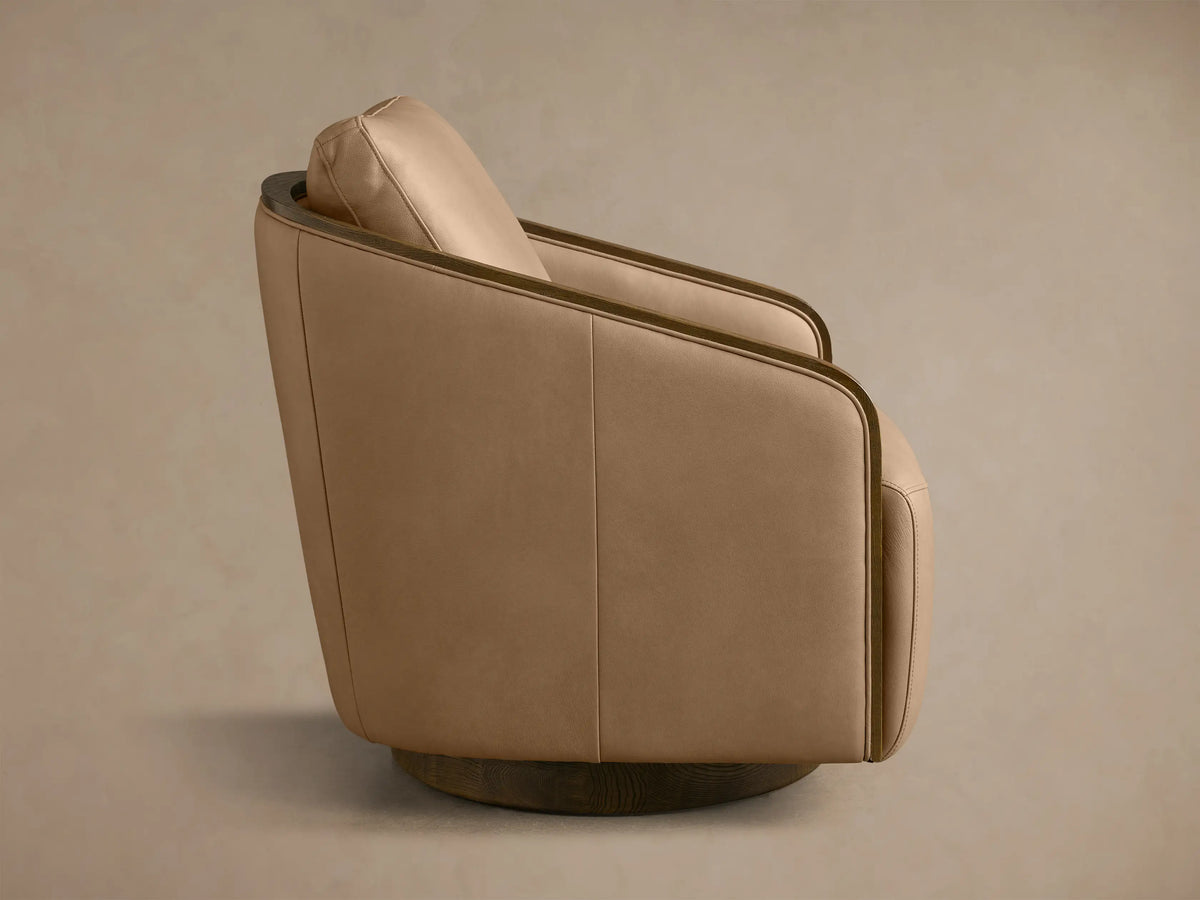 Rear view of the tan Pomona Leather Swivel Chair with exposed dark oak arm edges and a dark oak swivel base.