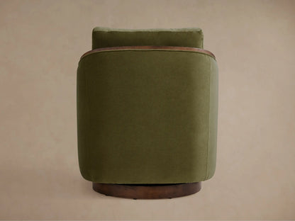 The Pomona Swivel Chair in olive green fabric, featuring oak edges on arms and base, viewed from an angle showing its solid form.