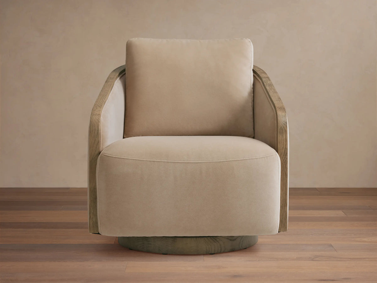 Beige Pomona Swivel Chair with exposed oak edges on the arms and a swivel base, positioned in a well-lit living room.