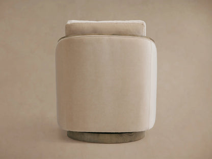 Pomona Swivel Chair in soft beige fabric, viewed from the side. Features exposed oak edges and round swivel base.