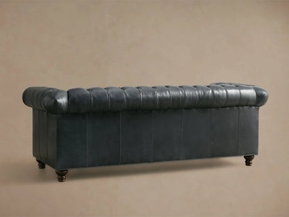 Close-up of the dark grey leather Berwick Leather Sofa, showing tufted back and seat, and a rolled armrest.