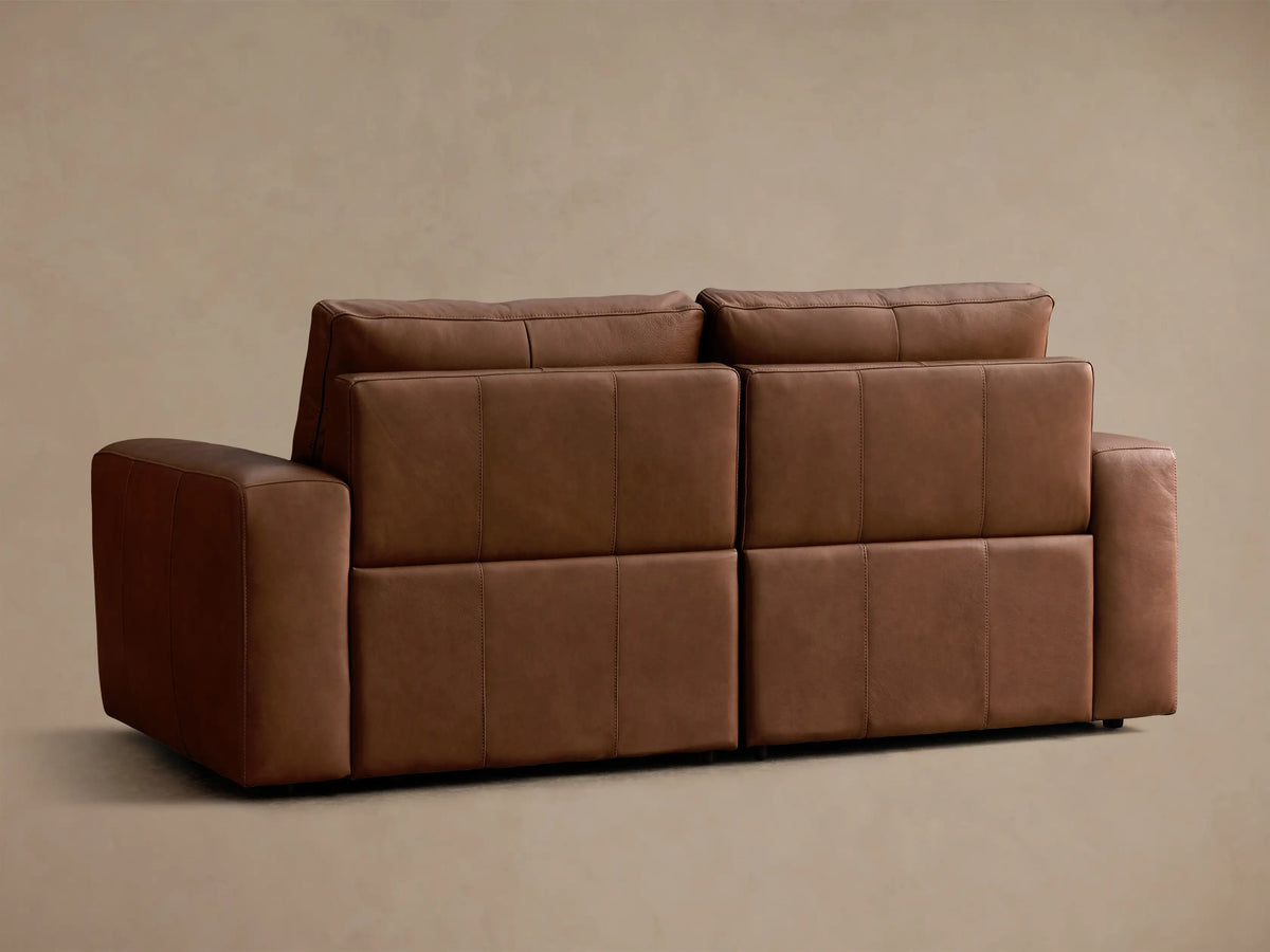 Close-up of the brown Brennan Leather Two-Piece Motion Sofa, highlighting its smooth leather texture and stitching details.