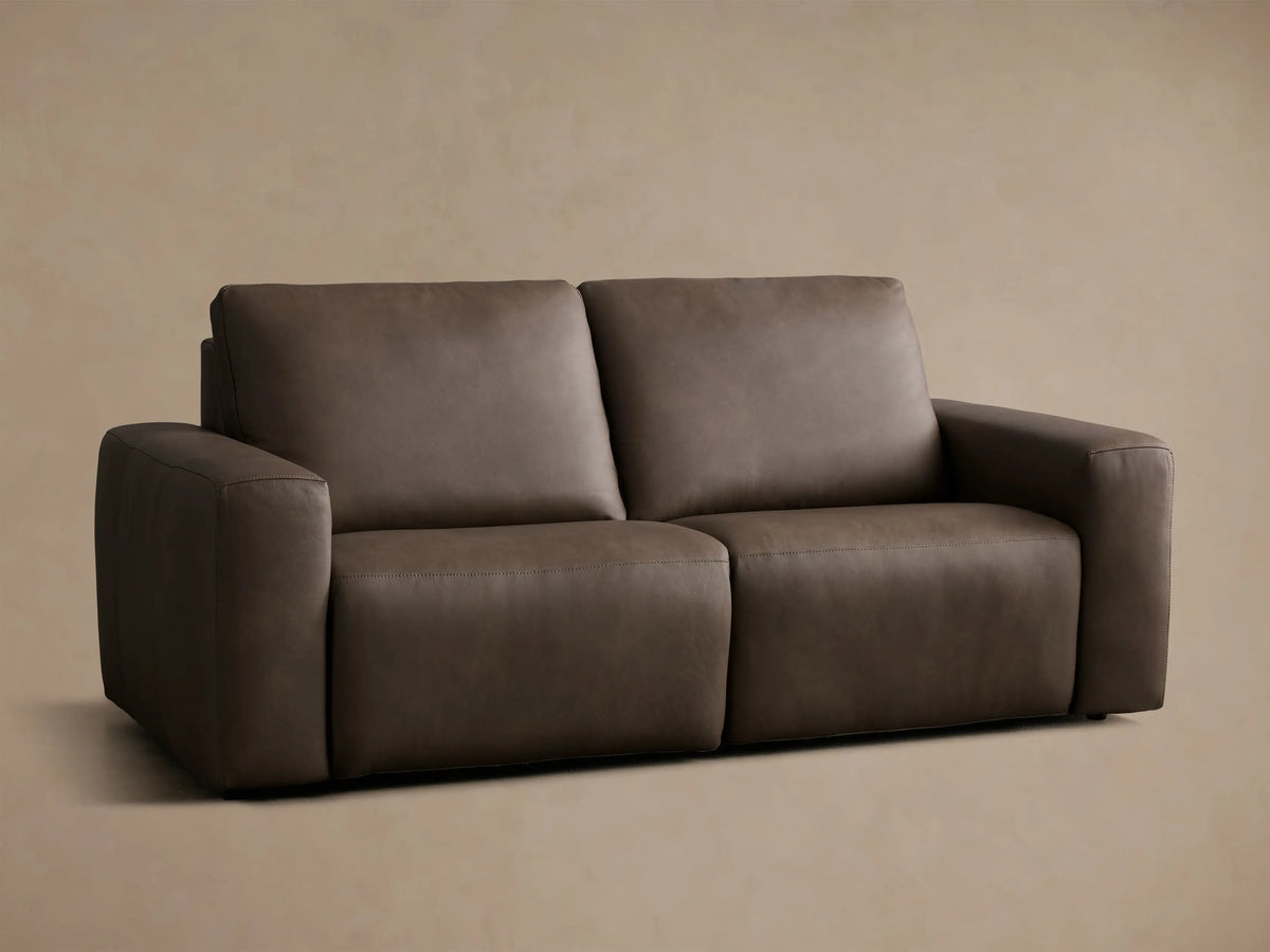 Front view of the dark brown Brennan Leather Two-Piece Motion Sofa, showing two plush seat cushions and wide armrests.