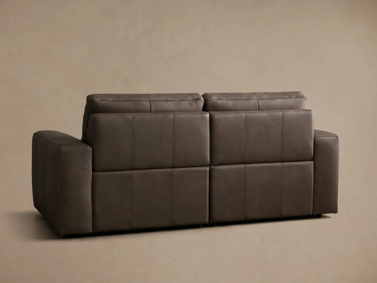 Front view of brown Brennan Leather Two-Piece Motion Sofa with left footrest extended.