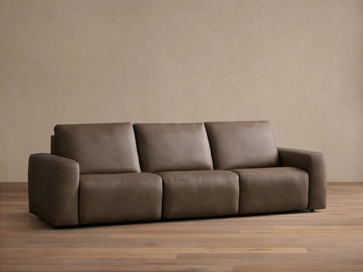 Front view of the brown leather Brennan Leather Three-Piece Motion Sofa, featuring three seats and wide squared arms.