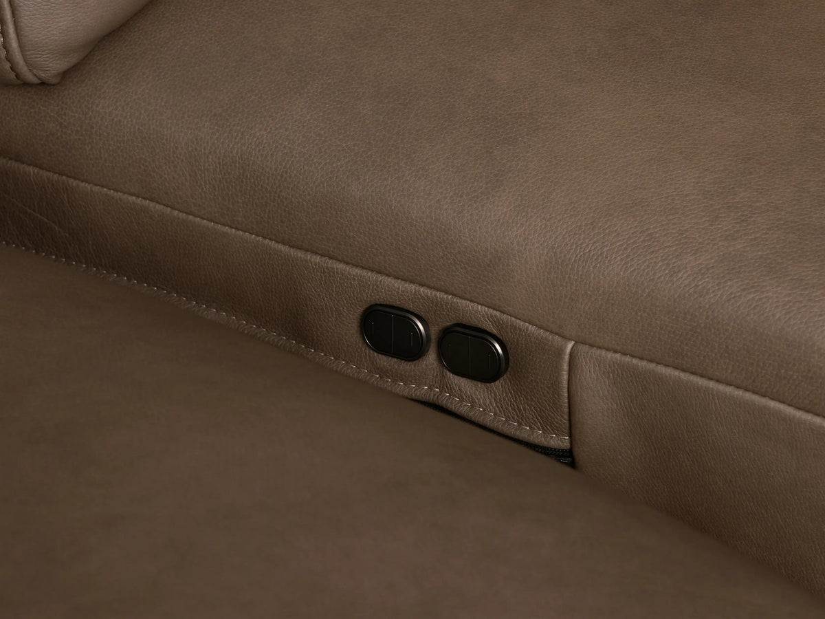 Front view of the taupe Brennan Leather Three-Piece Motion Sofa, with three plush reclining seats, integrated headrests, and wide, squared arms.