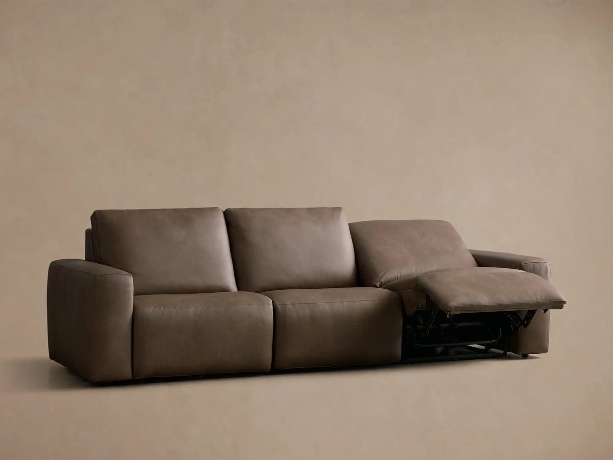 Rear view of the taupe Brennan Leather Three-Piece Motion Sofa, showing its three distinct back and lower sections.