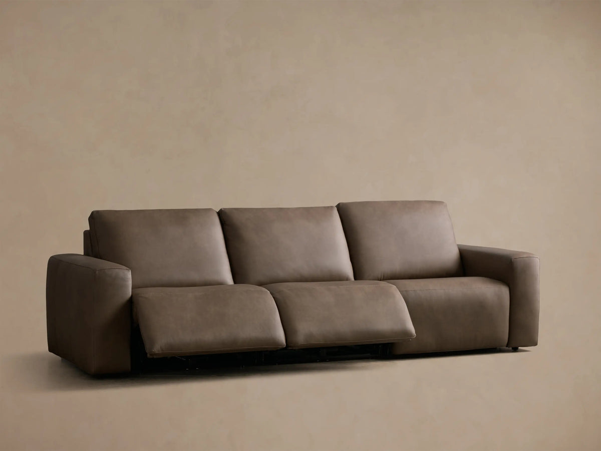 Front view of a taupe Brennan Leather Three-Piece Motion Sofa with the rightmost recliner extended.