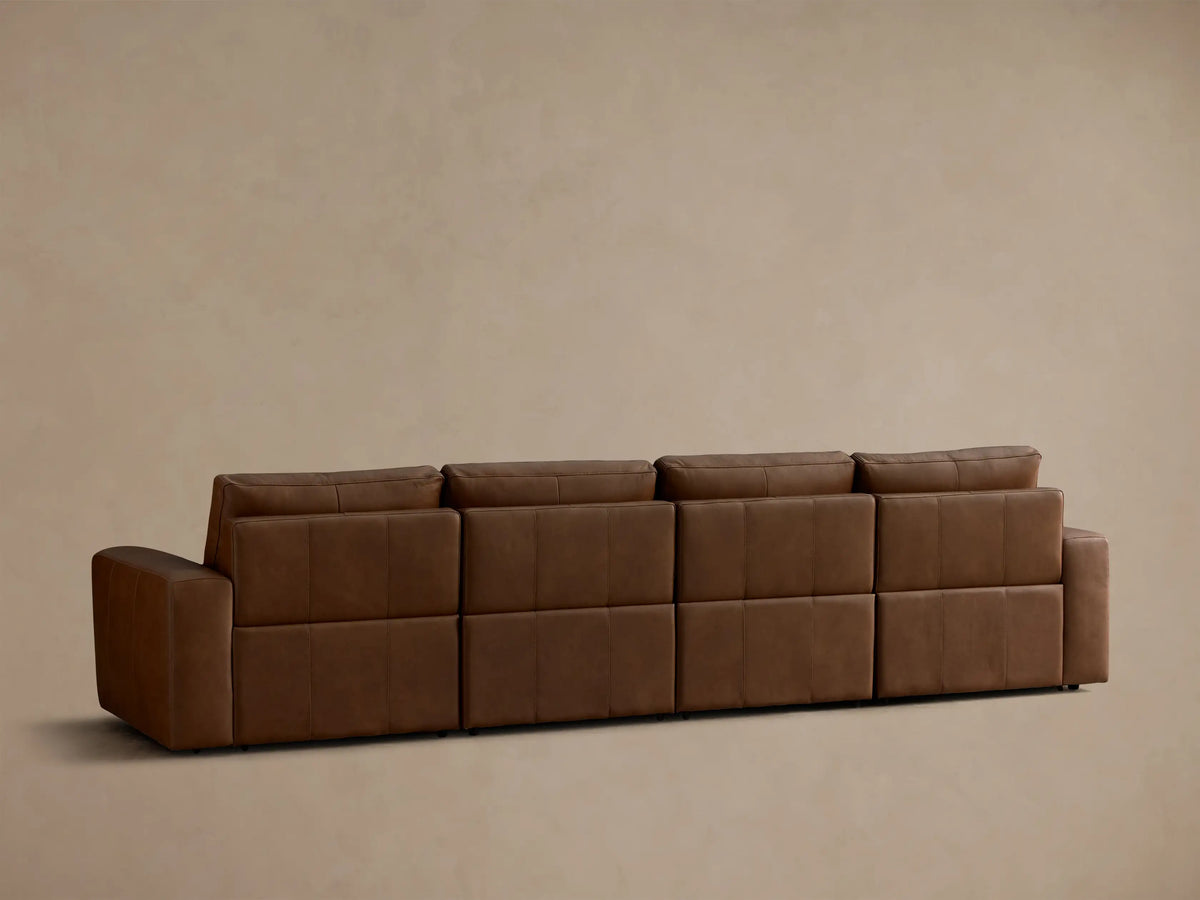 Close-up of the brown leather texture on the seat and back cushions of the Brennan Leather Four-Piece Motion Sectional.