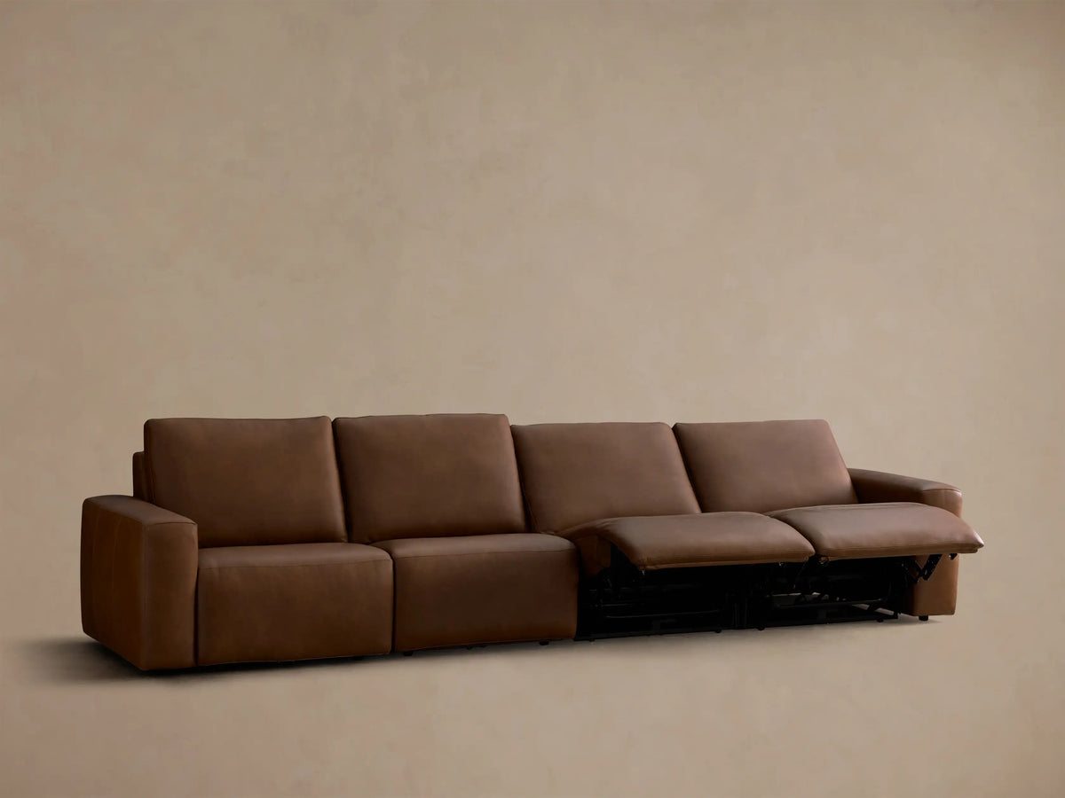 Rear view of the brown Brennan Leather Four-Piece Motion Sectional, showing the back of the four recliner sections.