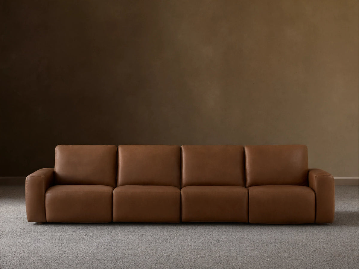 Front view of the brown Brennan Leather Four-Piece Motion Sectional with four plush sections.