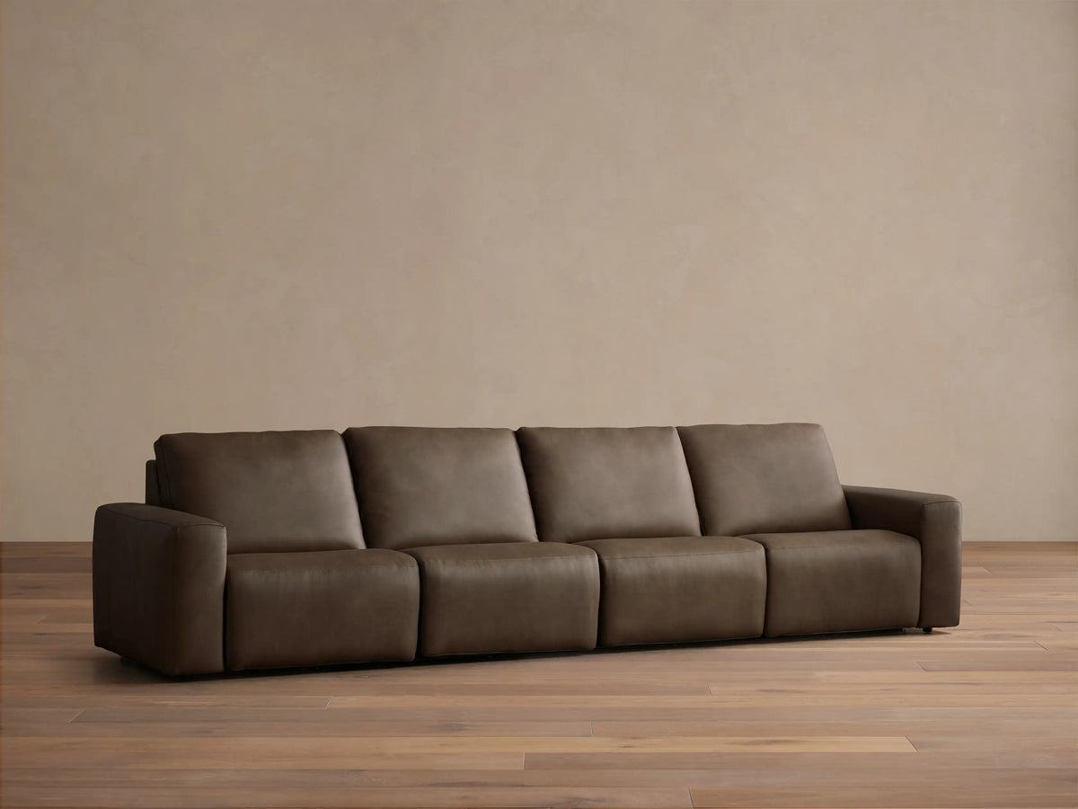 Front view of a brown Brennan Leather Four-Piece Motion Sectional, featuring four cushioned seats and two armrests.