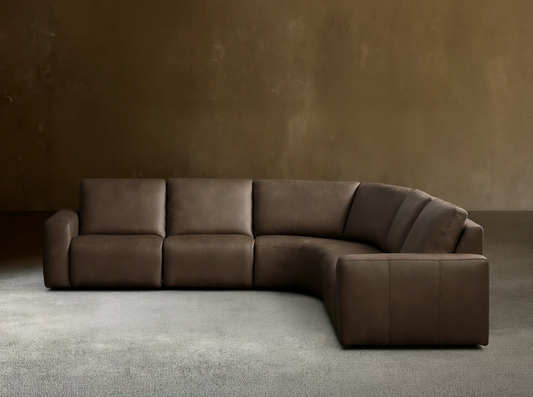 Front view of the brown Brennan Leather Five-Piece Motion Corner Sectional, an L-shaped sofa with smooth cushions.