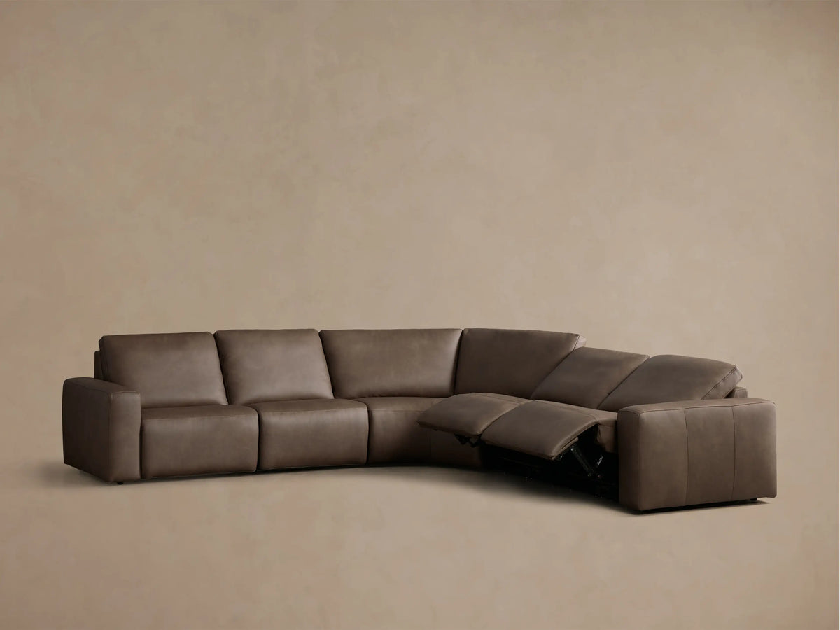 Rear view of the brown Brennan Leather Five-Piece Motion Corner Sectional, showing its curved shape and panel details.