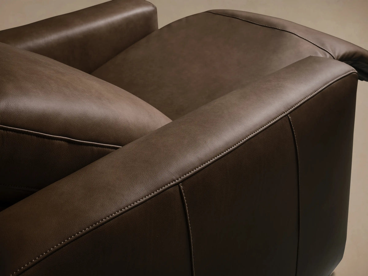 Front view of the Brown Brennan Leather Motion Recliner, showing its footrest extended and backrest slightly reclined.