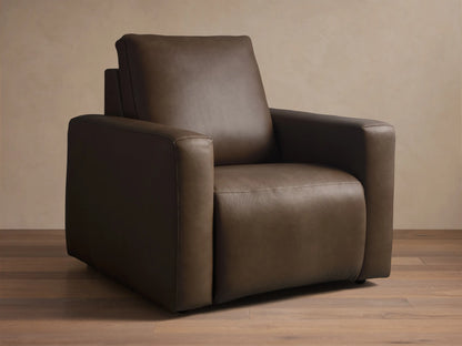 Close-up, angled view of the brown Brennan Leather Motion Recliner, highlighting the leather texture and detailed stitching on the armrest and seat.