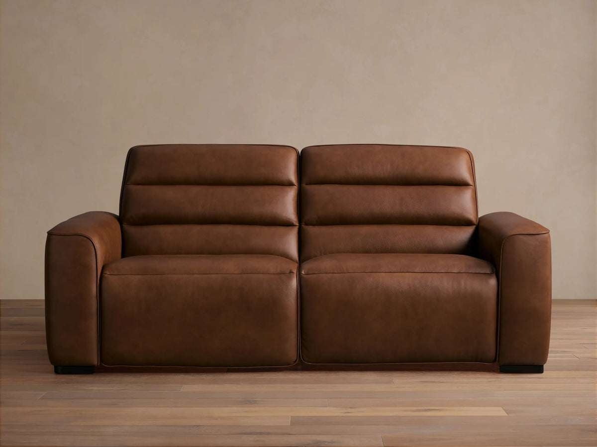 Front view of Borough Leather Two-Piece Motion Sofa, rich warm brown leather, modern design with two seats, horizontally tufted back.
