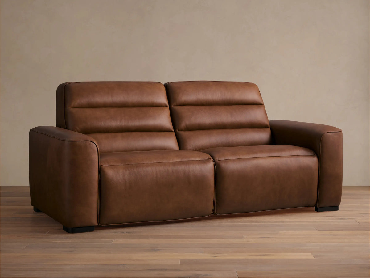 Front view of Borough Leather Two-Piece Motion Sofa, rich warm brown leather, modern design with two seats, horizontally tufted back.
