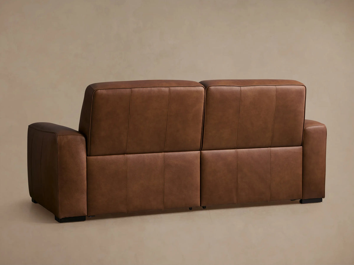 Borough Leather Two-Piece Motion Sofa in warm brown. Both power recliners slightly reclined, footrests extended, padded cushions.