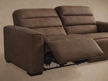 Close-up of Borough Leather Two-Piece Motion Sofa. Two black oval recline control buttons in brown textured leather.
