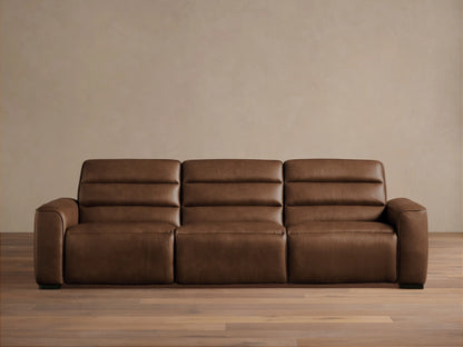 Front view of Borough Three-Piece Motion Sofa in rich brown leather, featuring plush, segmented cushions, on a wood floor.