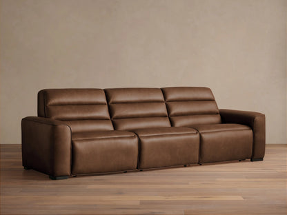 Front view of Borough Three-Piece Motion Sofa in rich brown leather, featuring plush, segmented cushions, on a wood floor.