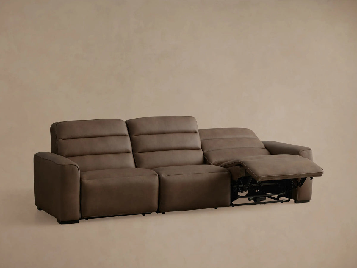 Angled back view of a taupe brown Borough Leather Three-Piece Motion Sofa. Shows three modular sections and armrests on a plain background.